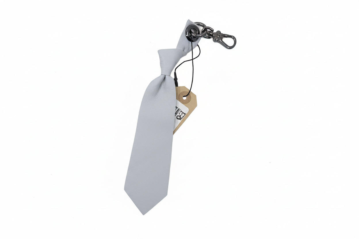 White tie-shaped keychain with a metal clip on a white background